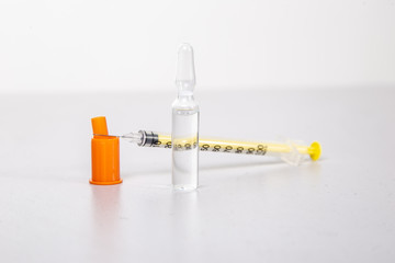 Insulin syringe with vial on a light table.