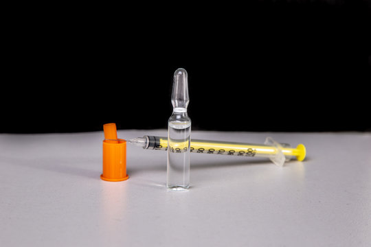 Insulin syringe with vial on a light table.