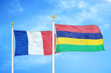 France and Mauritius two flags on flagpoles and blue cloudy sky