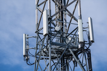 5G technology. Telecommunications and Wireless Cell Equipment Tower with Directional Mobile Phone Antenna against blue sky.