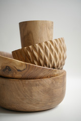 Wooden utensils for food on a white isolated background. Hand-made plates stand on top of each other. Empty round tray, natural wood plate. Eco-friendly cookware.