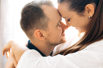 Close-up photo of a hugging couple in love, indoors