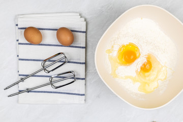 Top view of smashed eggs in flour ready for creating dough