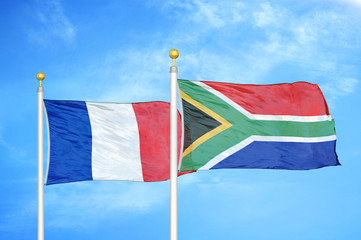 France and South Africa two flags on flagpoles and blue cloudy sky