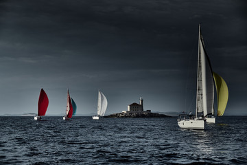Sailboats compete in a sailing regatta at sunset, sailing race, reflection of sails on water,...