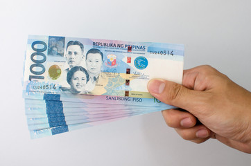 One thousand Philippine peso held by the fingers - obrazy, fototapety, plakaty