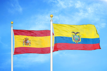 Spain and Ecuador two flags on flagpoles and blue cloudy sky