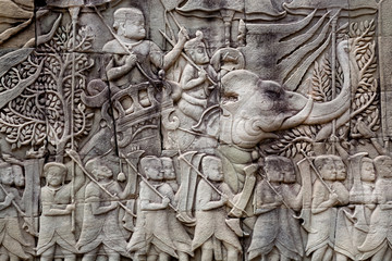 Historical relief with Khmer soldiers and elephants on the 12th century wall of Bayon temple, Cambodia. Historical artwork in Angkor. UNESCO world heritage site