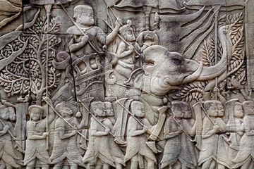 Historical relief with Khmer soldiers and elephants on the 12th century wall of Bayon temple,...