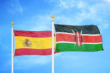 Spain and Kenya two flags on flagpoles and blue cloudy sky