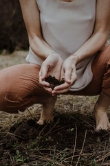 woman with hands in dirt from earth
