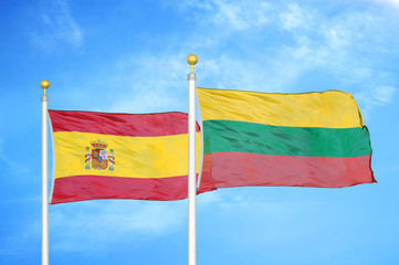 Spain and Lithuania two flags on flagpoles and blue cloudy sky