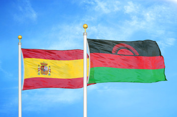 Spain and Malawi two flags on flagpoles and blue cloudy sky