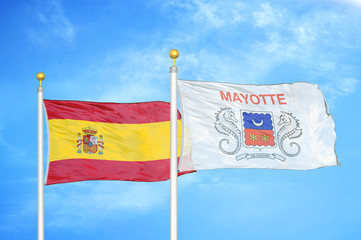 Spain and Mayotte two flags on flagpoles and blue cloudy sky