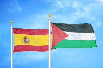 Spain and Palestine two flags on flagpoles and blue cloudy sky