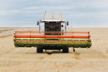 A machine for collecting ripened wheat. The harvester rides through a wheat field.