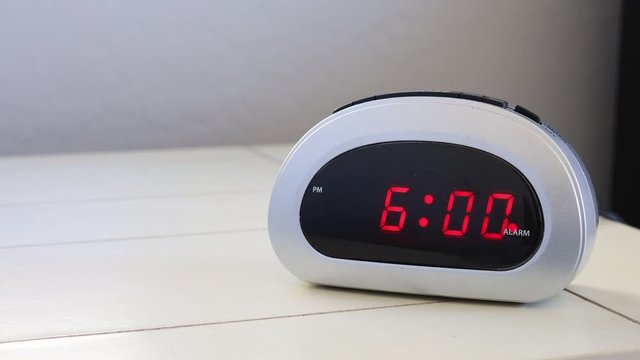 Hand Shutting off Alarm Clock