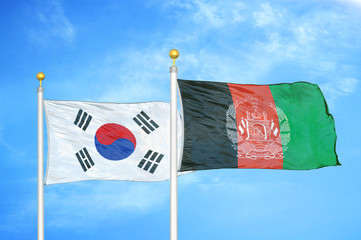South Korea and Afghanistan  two flags on flagpoles and blue cloudy sky