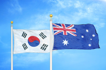 South Korea and Australia  two flags on flagpoles and blue cloudy sky