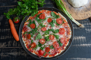 Raw homemade Pizza and Ingredients on white wooden table, top view