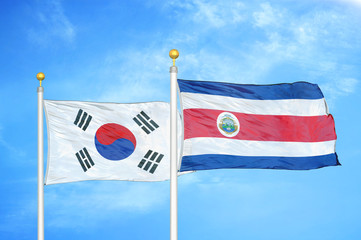 South Korea and Costa Rica two flags on flagpoles and blue cloudy sky