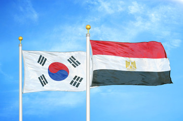 South Korea and Egypt two flags on flagpoles and blue cloudy sky