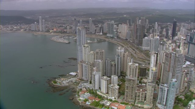 Aerial view over Panama Bay, yacht club, coastal strip with traffic, downtown buildings and skyscrapers, cloudy weather and filmed with the Cineflex