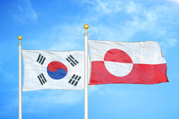 South Korea and Greenland two flags on flagpoles and blue cloudy sky