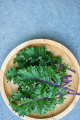 Red Russian Kale Leaves o Wooden Plate with Copy Space