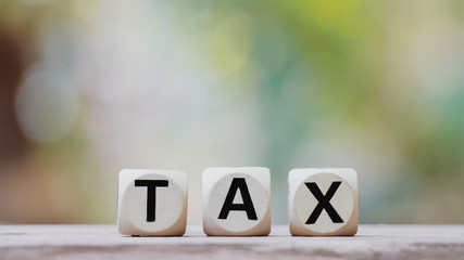 Tax concept with tax wooden cube