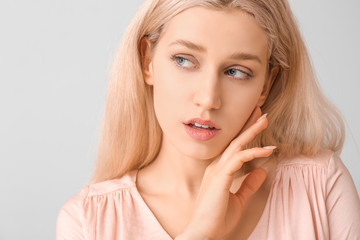 Young woman with beautiful makeup on light background