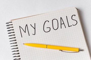 Inscription in copybook MY GOALS. Pen and notebook. Close up.