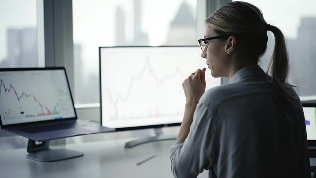 Female broker browsing revenue charts for analyzing corporate risk during working day in office interior, Caucasian female administrator making online accounting networking digital block chain
