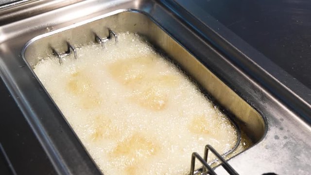 fried potatoes in deep frying hot oil, french fries
