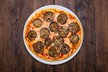classic Italian pizza with eggplant on a wooden table