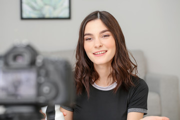 Young female blogger recording sports video at home