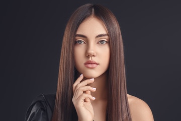 Young woman with beautiful straight hair on dark background