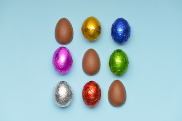 Sweet chocolate eggs on color background