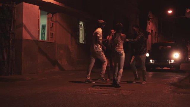 Men and women dancing together on road and having fun at night