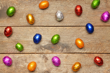 Sweet chocolate eggs on wooden background
