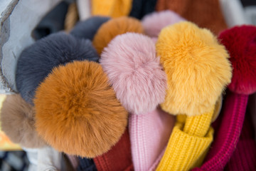 Colorful knitted wolol balls decorated on a knitted wool hats