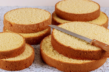 Sponge cake layers with knife. Making wedding cake.