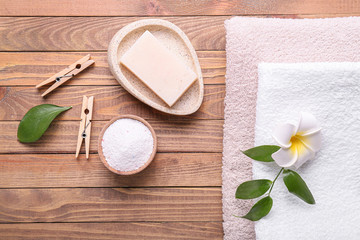 Towels and laundry detergents on wooden background