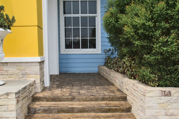 Rock stairs and floor with ornament plants beside the house