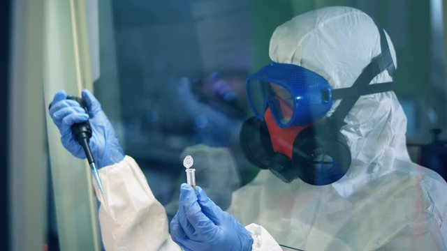 Woman works with laboratory equipment while researching coronavirus.