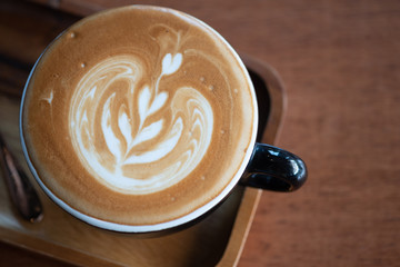 Hot latte coffee with latte art in black cup