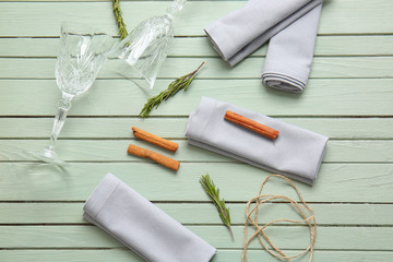 Napkins with floral decor and glasses on wooden background