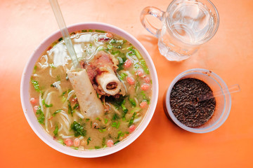 Bone marrow soup also known as soup gear box.served in a pink bowl. The glass contain word TAHAN PANAS or hot resistant