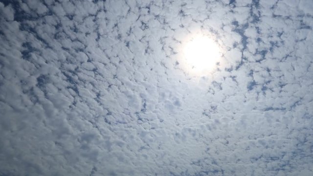 Beautiful cirrocumulus clouds  with bright sunlight & sun rays breaking through cloud, TimeLapse. Cotton candy fluffy cloudscape in tropical summer or spring morning sunlight on sunny day blue sky