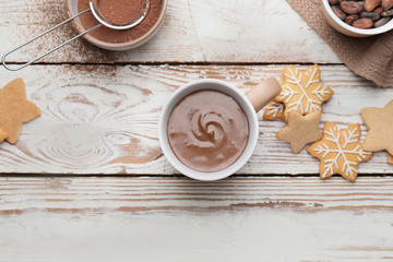 Cup of hot chocolate and cookies on wooden background